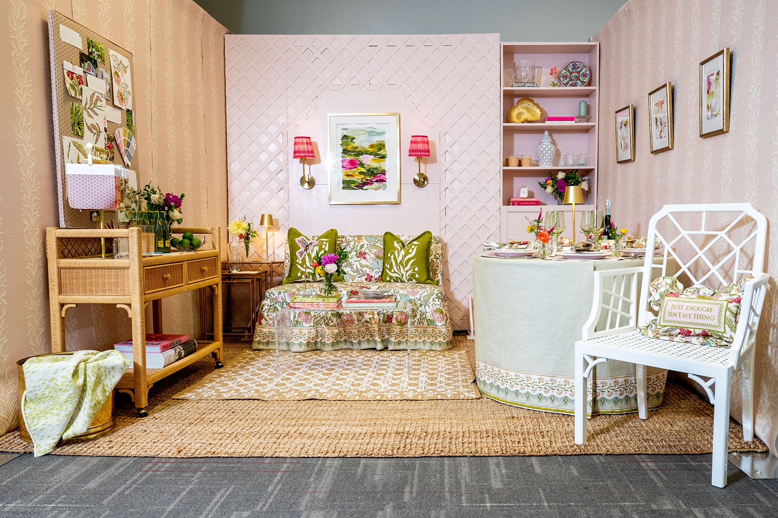 Photo of a room with pink walls, a bookshelf, a floral seating area.
