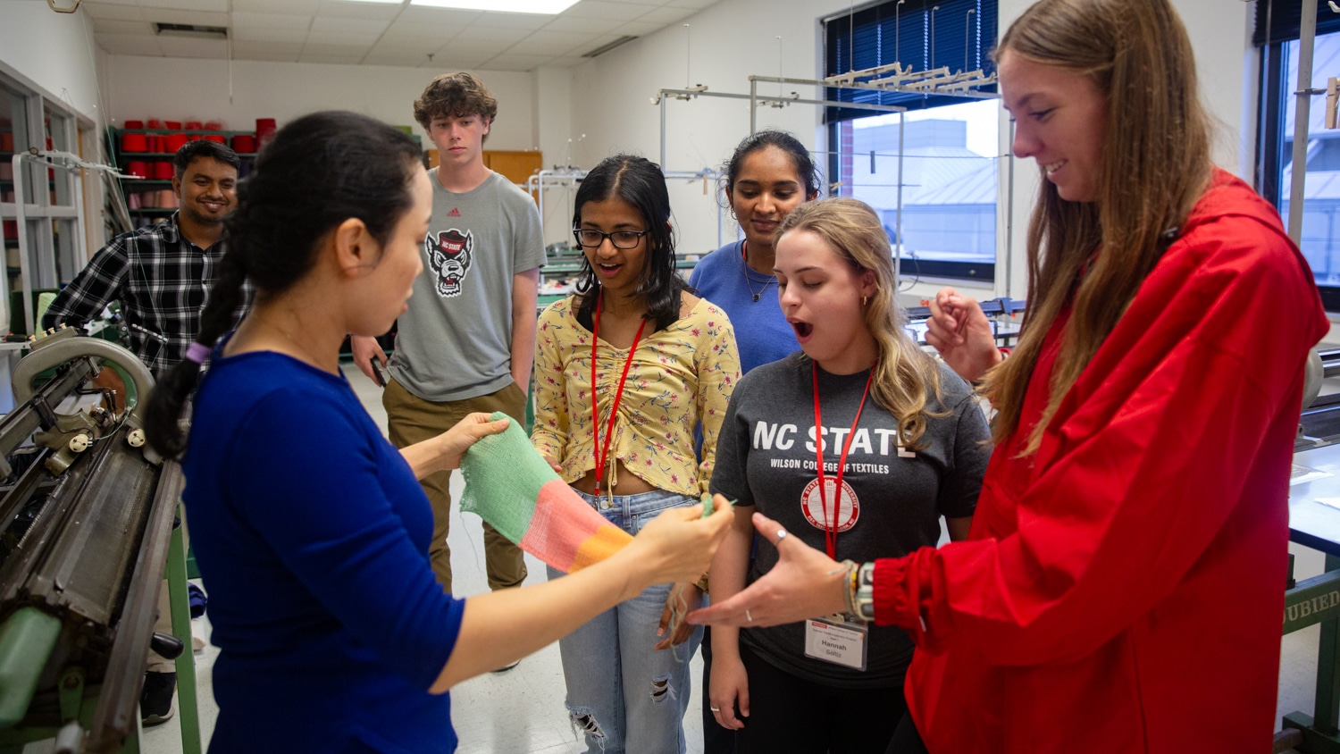 Textile engineering and technology students see a sample they've just finished machine knitting in the Wilson College lab. It's part of a larger e-textile project they worked on throughout the week.