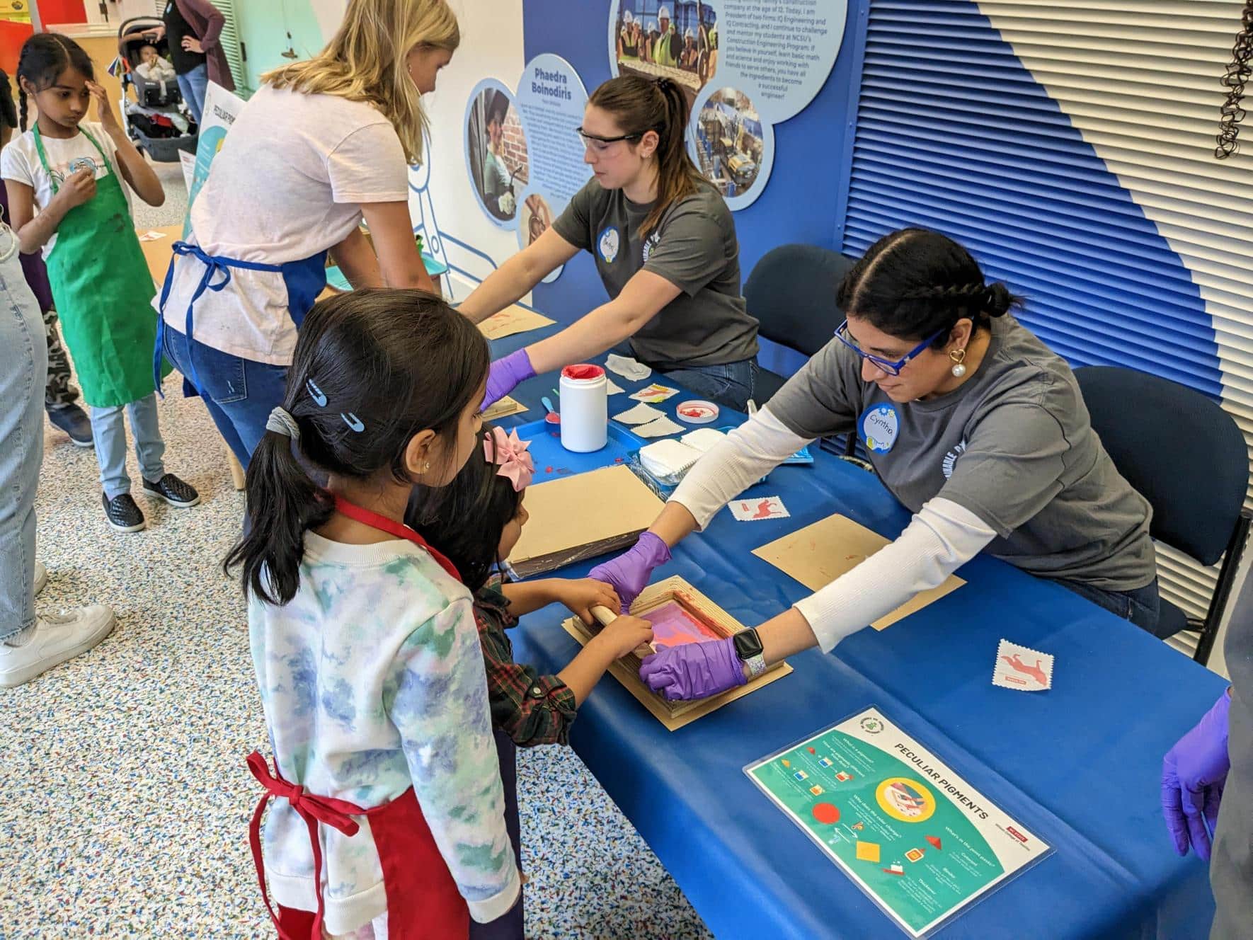 Children guided by a student through screen printing
