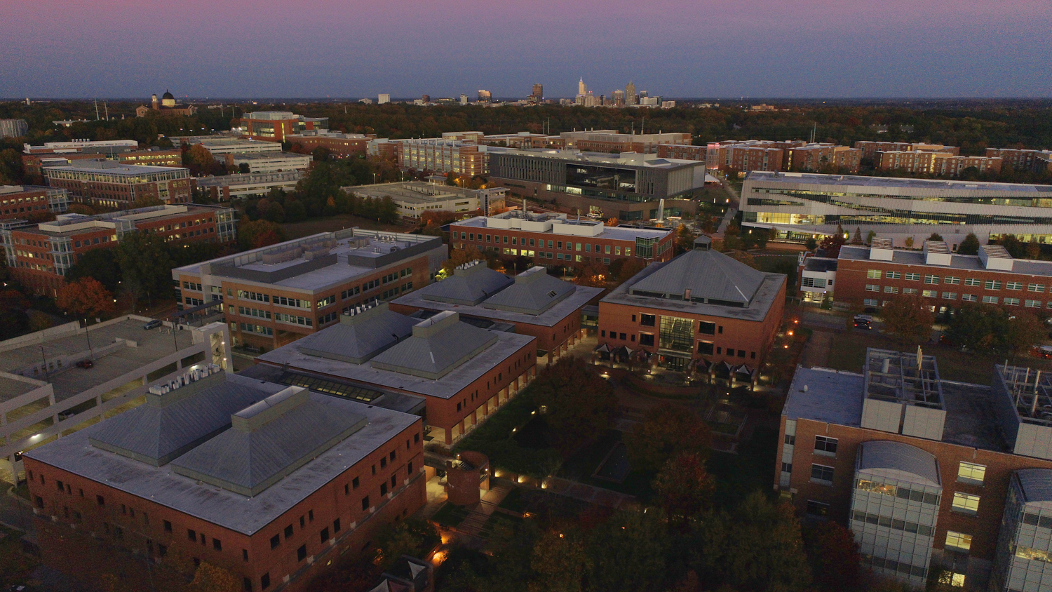 Wilson College of Textiles aerial view at sunset with Raleigh skyline visible