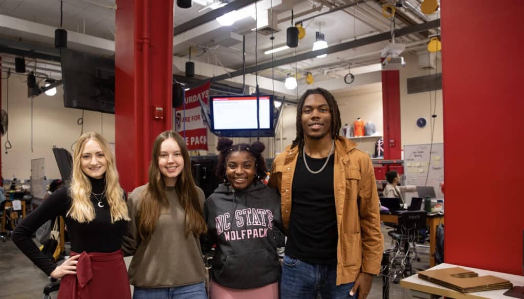 Team members pose together in senior design studio.