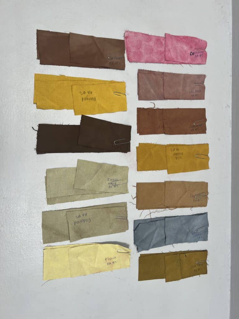 Various natural dye swatch samples displayed on table. 