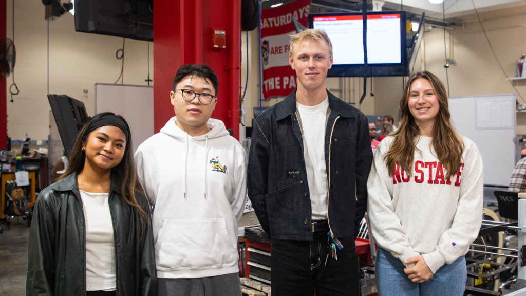 Team members stand together in Senior Design studio.