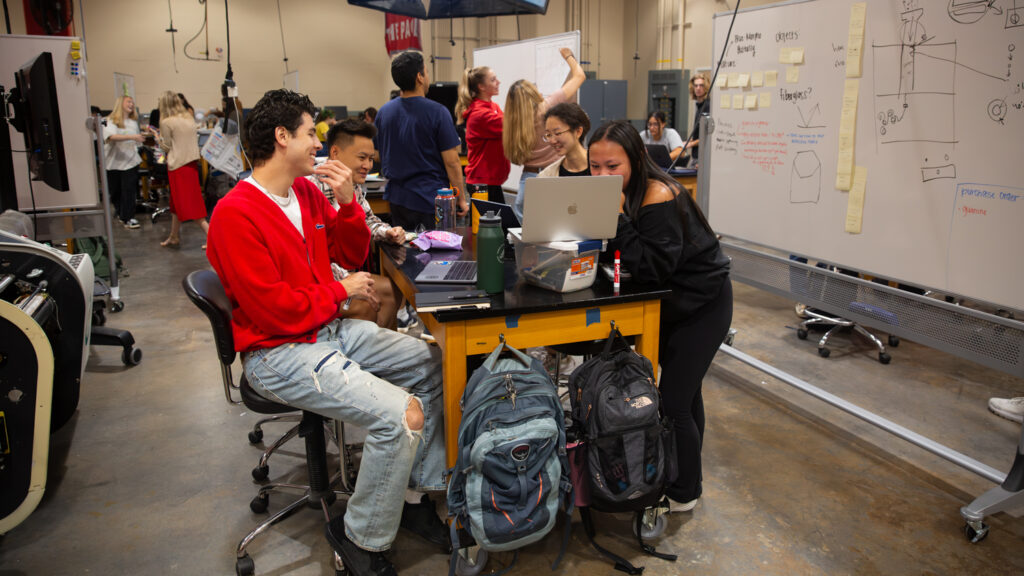 Team members brainstorm around table in the studio. 