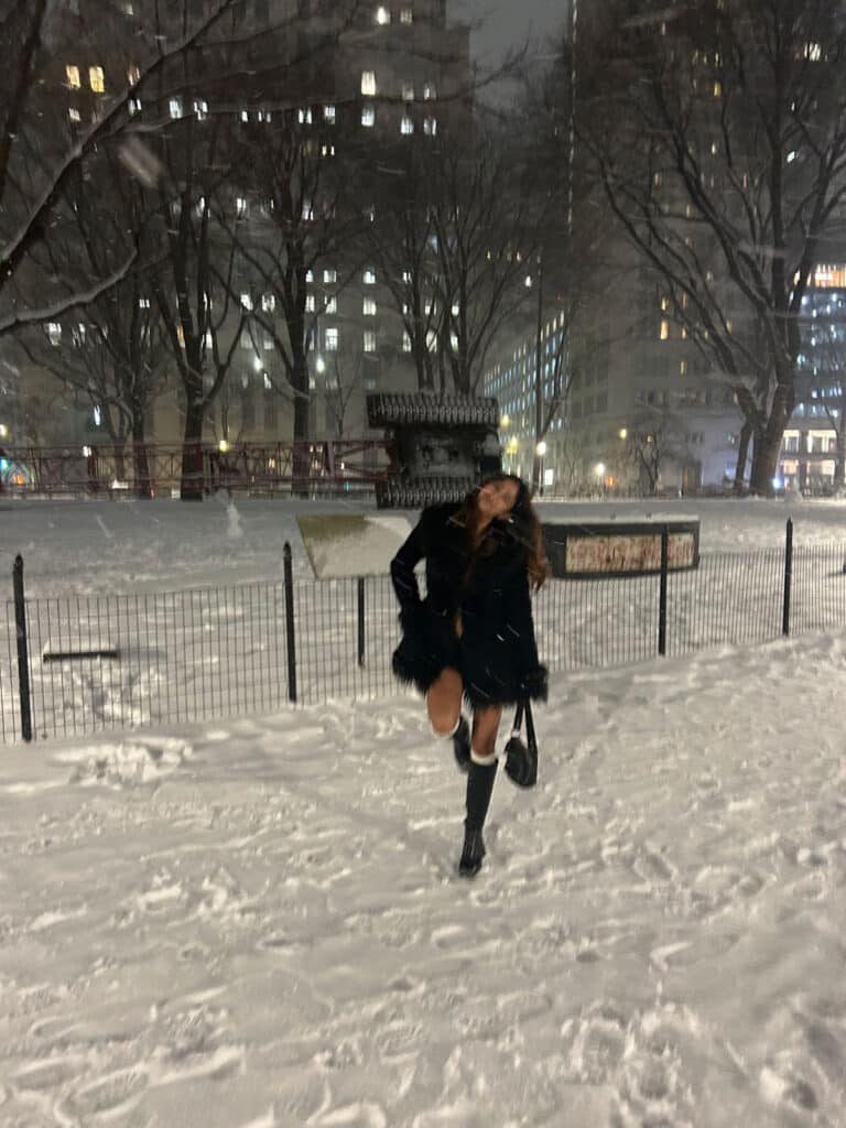 Young woman posing while standing in the snow in New York City.