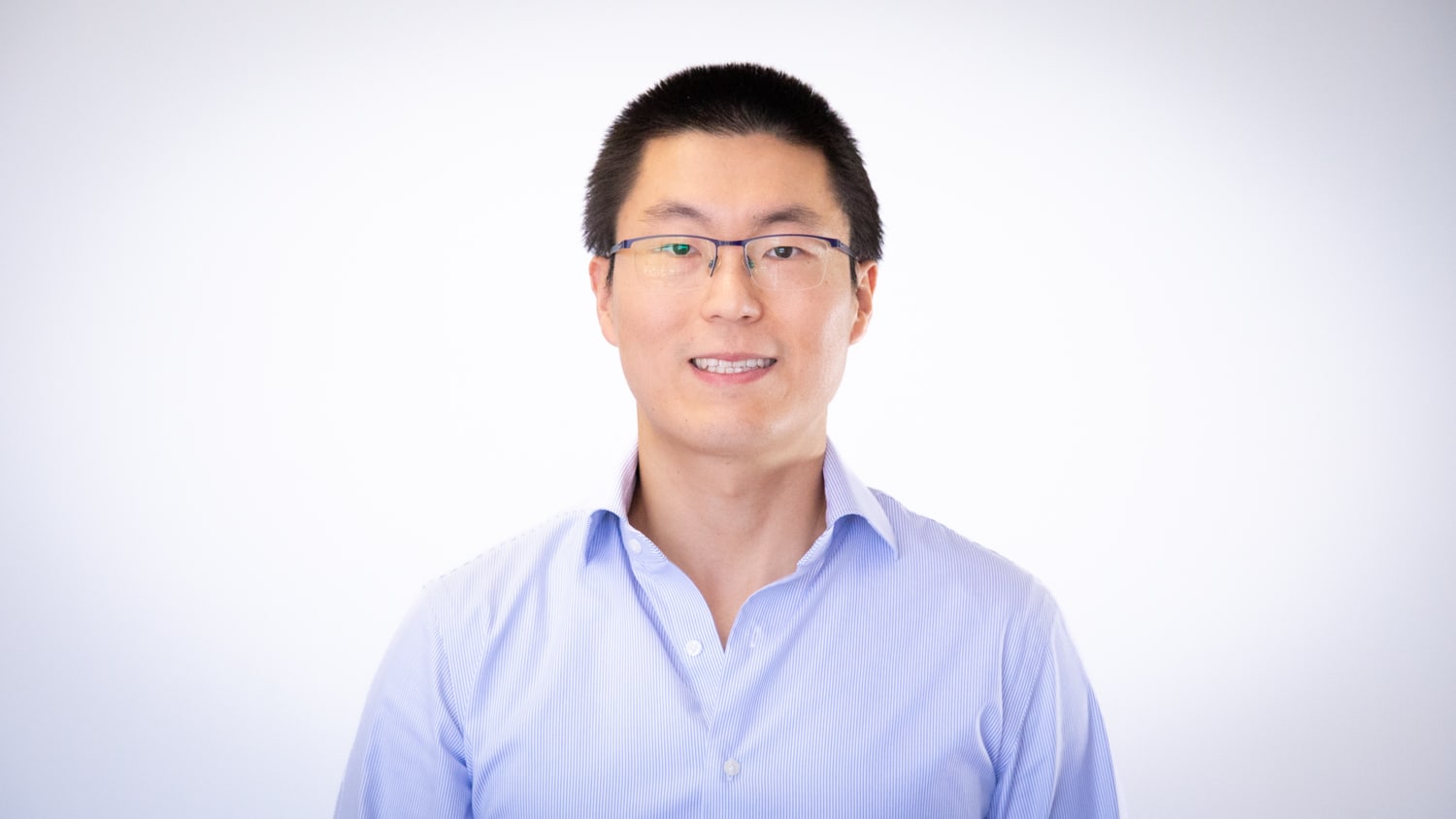 A photo of Jialong Shen in front of a white backdrop.
