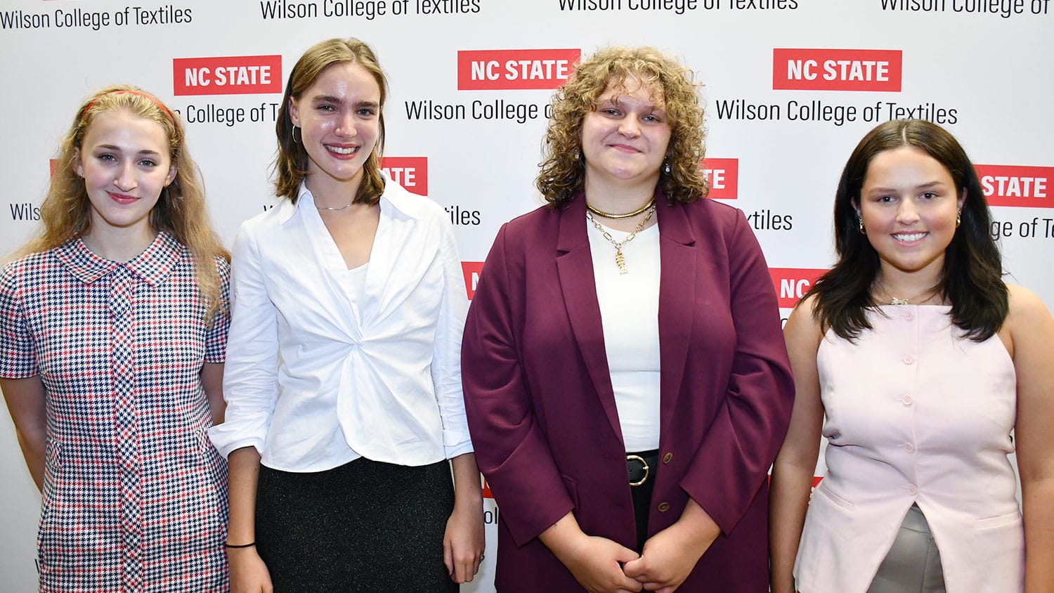 Four students smile at the camera