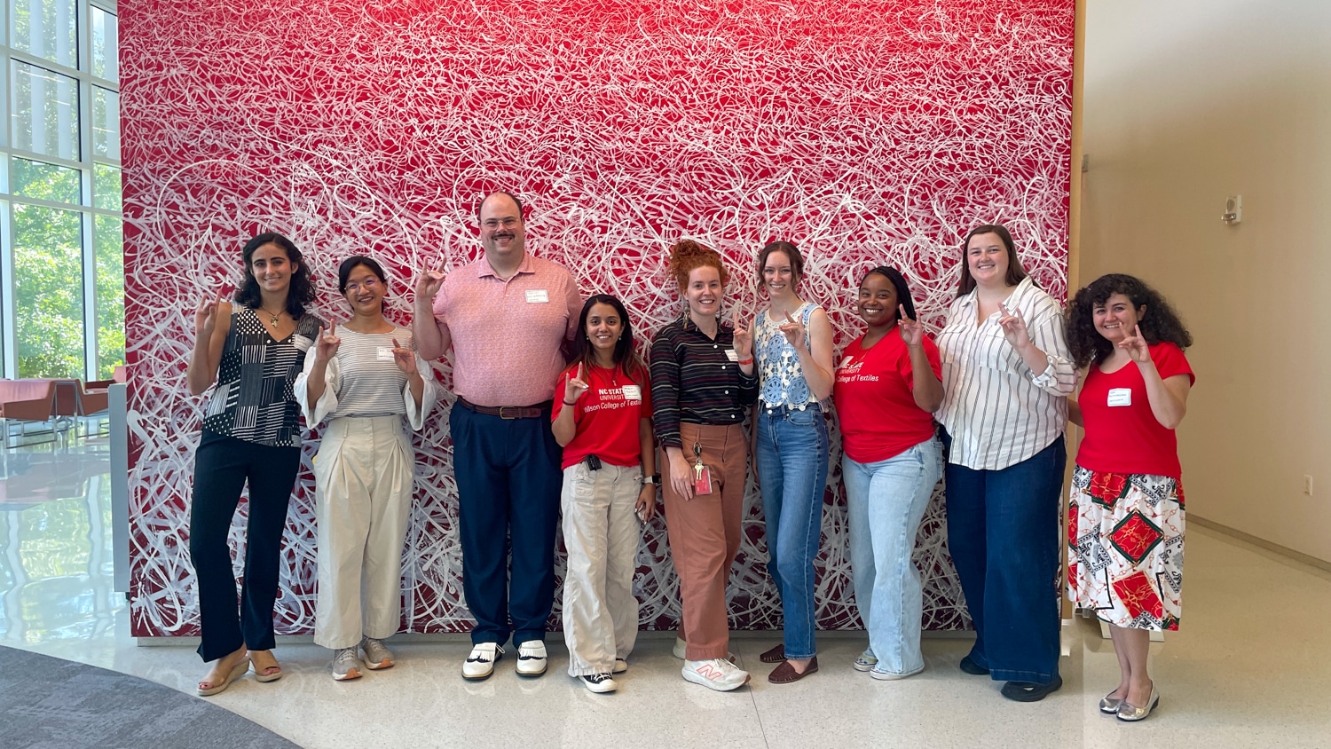 A group photo with the participants in the Flex Factory Summer Innovation Program holding up the "Go Pack" hand sign.