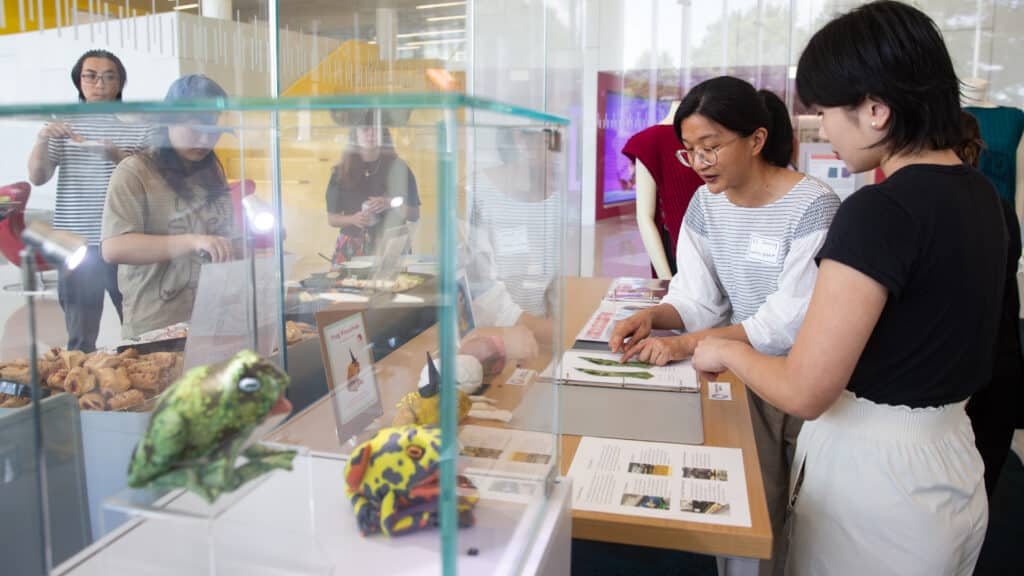 KC Soong shows a student the patterns for her DIY frog pincushion kit at the Hunt Library showcase.