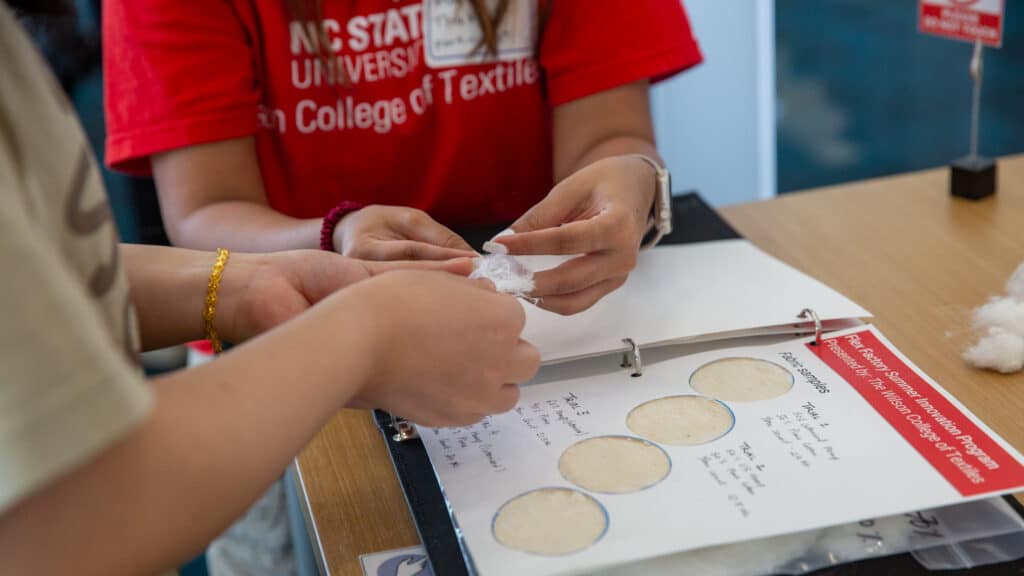 Mayuri Thakur points out the texture of the hemp blend on her presentation table at Hunt Library.