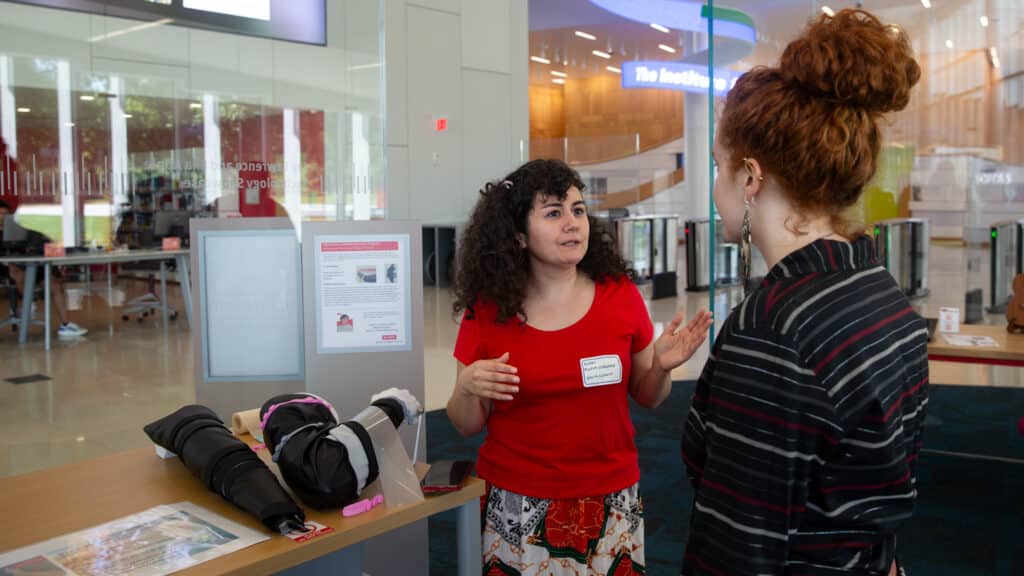 Hoorieeh Mahmoodabadi presents her compression sleeve project to another student.