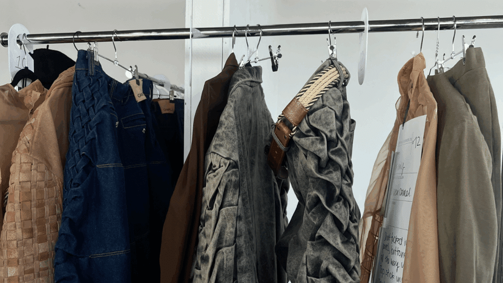 A rack of clothing featuring neutral outerwear pieces for a New York Fashion Week show.