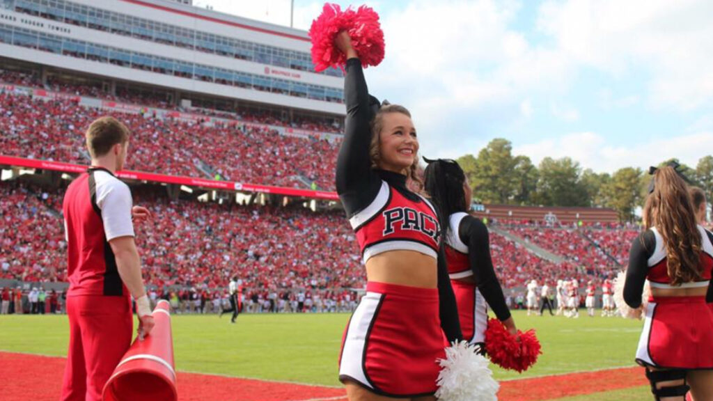 Image of Kaylee on the football field in her cheerleading gear.