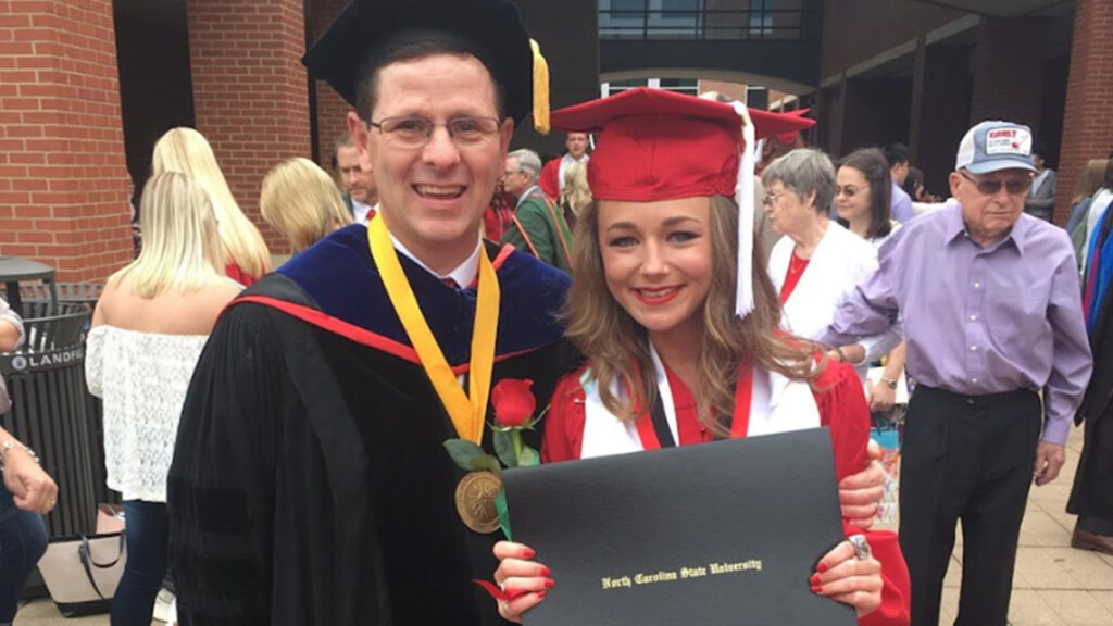 Kaylee Smith Wagner smiles while standing next to Professor Jeff Joines.