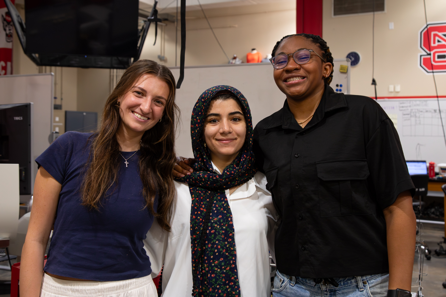 Devon Poulin, Fatemeh Heydari and Jordan Everett stand for a posed group photo in the Senior Design Lab.