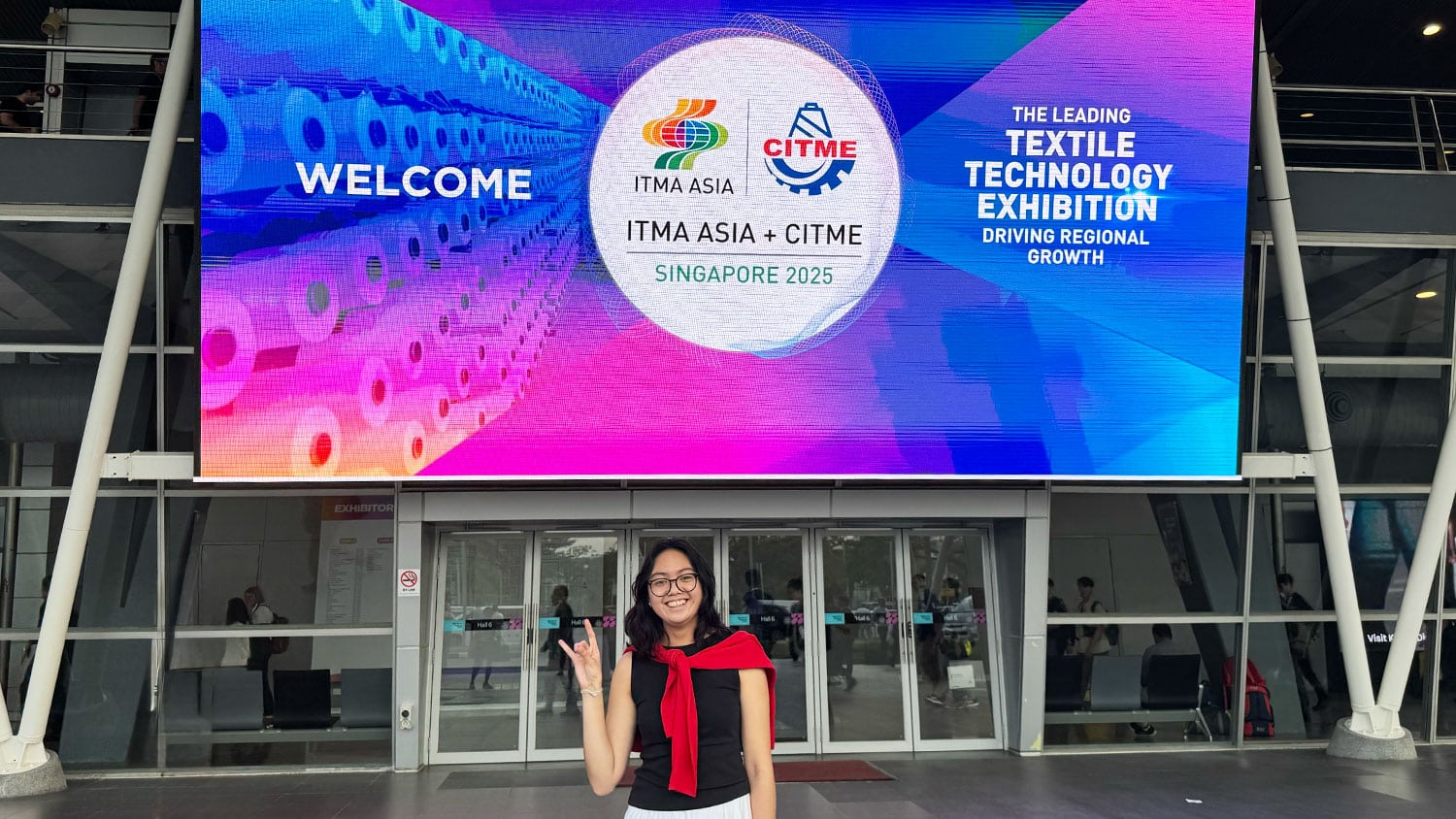 Smiling student in front of event signage