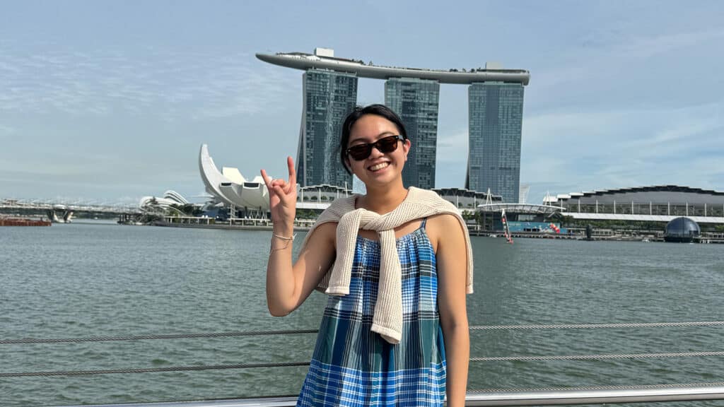 Student smiling while standing in front of the Marina Bay Sands landmark.