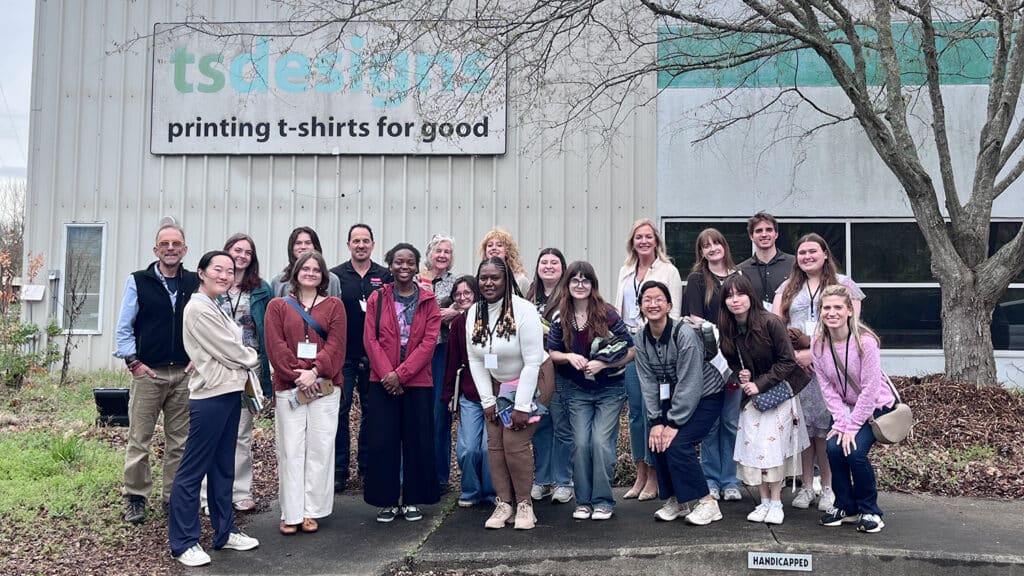 Amy smiles while standing with a large group of students.
