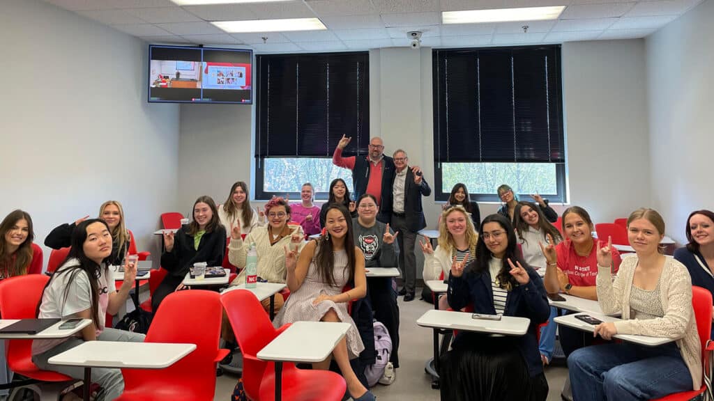 Students smiling alongside Michael and David Hinks