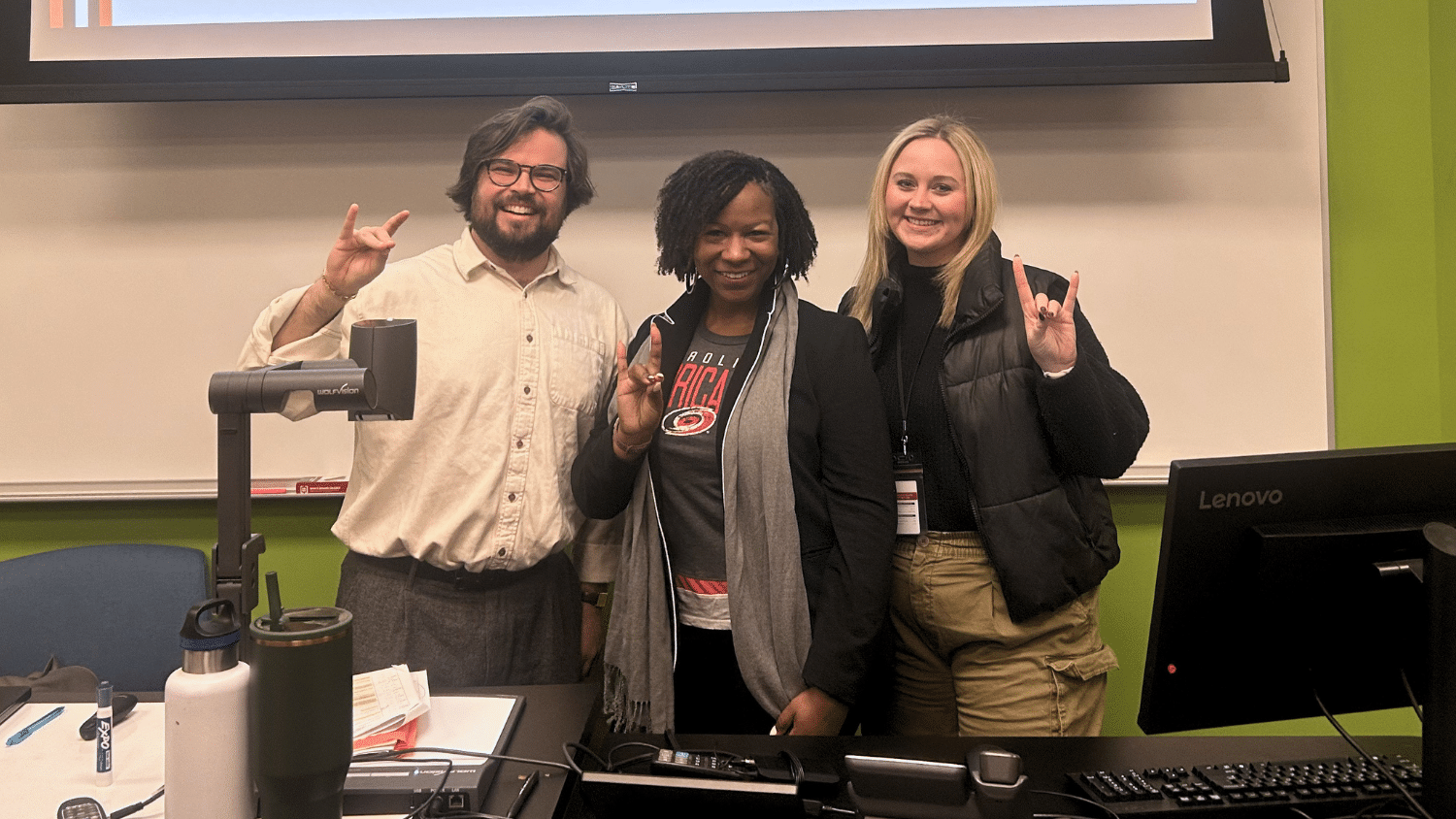 The marketing team from Carolina Hurricanes and Dr. Delisia Matthews make the Go Pack sign with their hands.