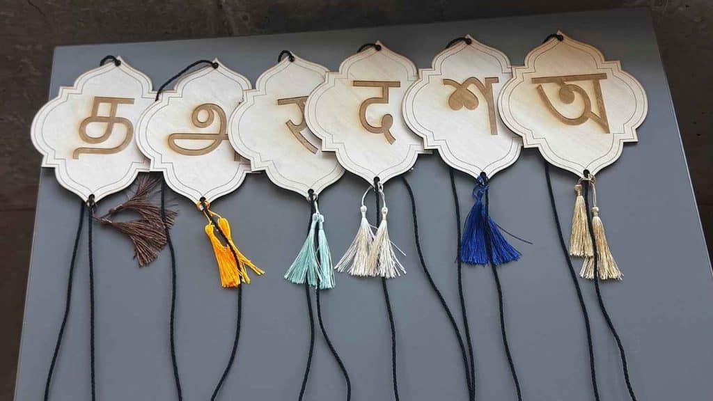 Wooden stands with engraved letters of the Indian alphabet.