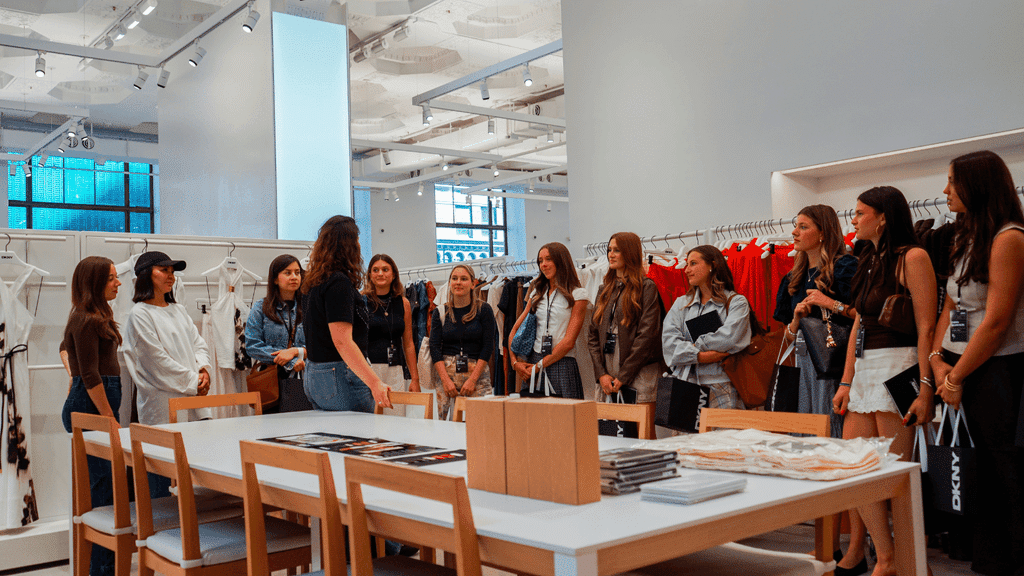Students of the CLASS: The NYC Experience receiving information from industry professionals at a fashion warehouse