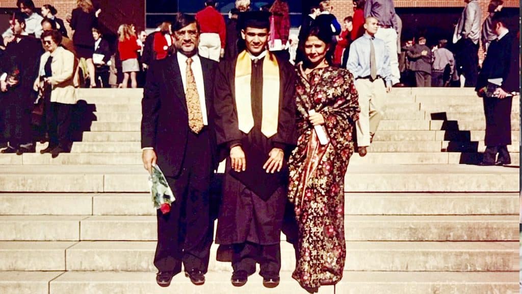 Amit Patodia smiles while wearing his graduation regalia. He's pictured alongside his mother and father, who traveled from India for the special day.