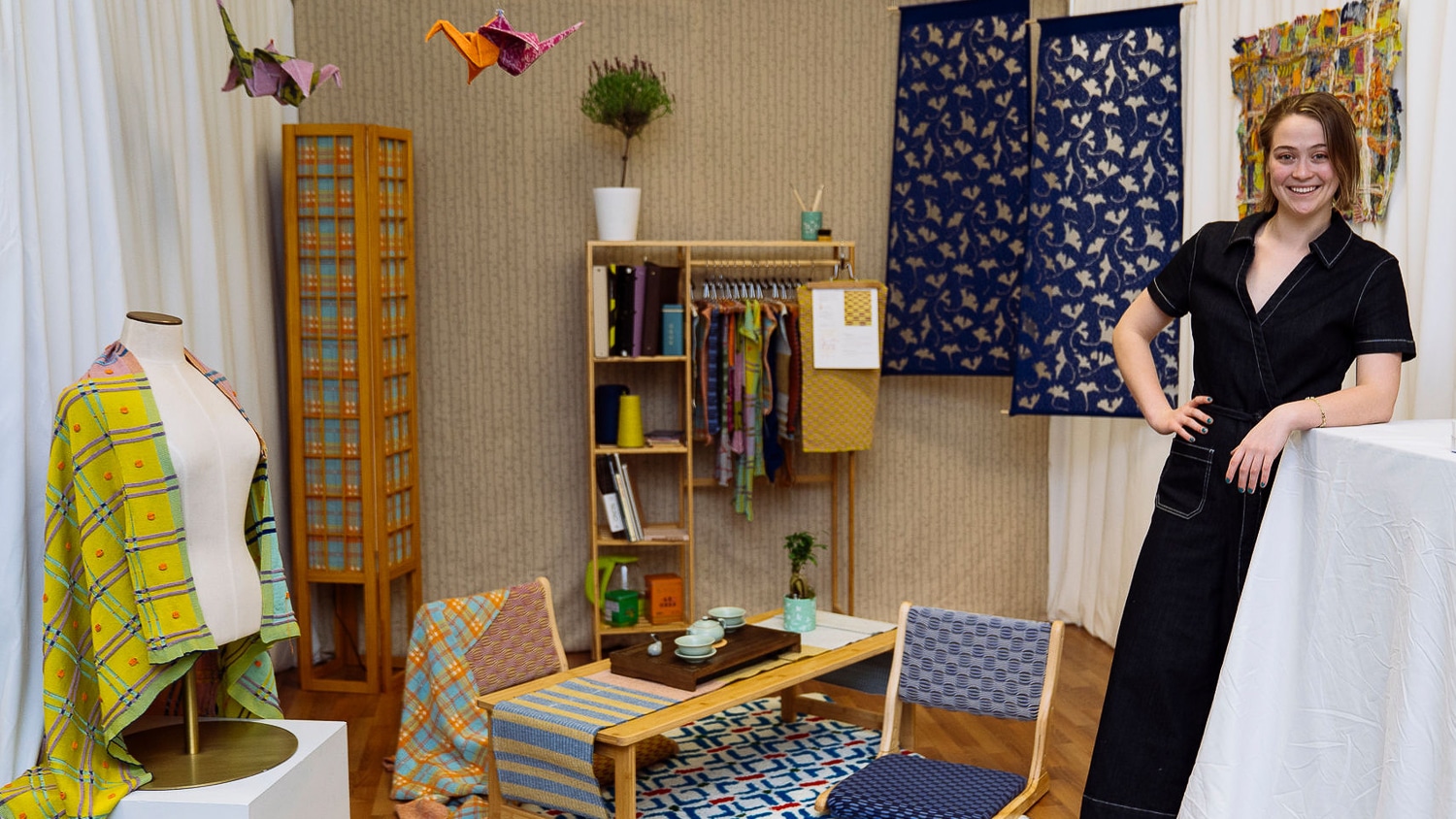 Student stands in front of senior design collection