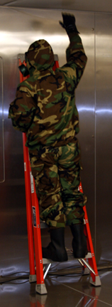 A volunteer test participant standing on a ladder